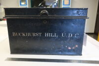 Metal black painted document box, with hinged lid, lock and two handles on either side. Painted on the front 'BUCKHURST HILL UDC' in white.